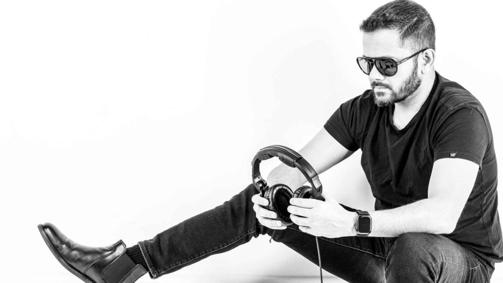  Rafi Alam sitting on floor holding black headphones

