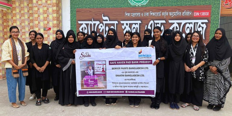 Students holding Safe Haven Pad Bank project banner.