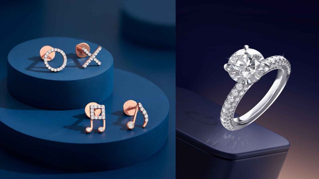 A curated display of Malabar Gold & Diamonds jewelry, featuring rose gold tic-tac-toe and music note diamond stud earrings alongside a brilliant round solitaire engagement ring with a micro-pave diamond band.