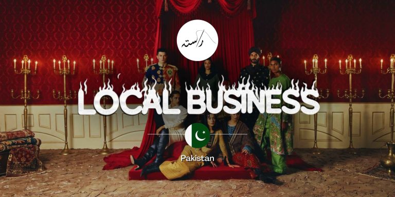 Rastah luxury fashion models posing in an opulent red velvet room with the Pakistan flag, showcasing artisanal South Asian streetwear for the Local Business feature.