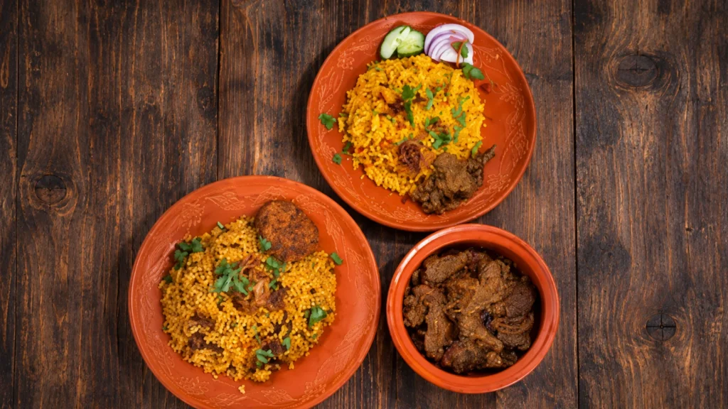 Steaming plates of kacchi biryani and beef tehari from Bangladeshi restaurants on Hillside Avenue in Jamaica, Queens, NYC